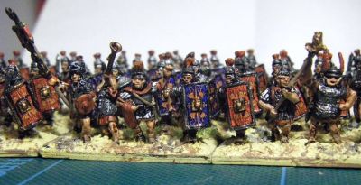 Early Imperial Roman Legionaries
Old Glory legionaries with Donnington, Corvus Belli and Essex officers and LBMS shield transfers. A rare "on the painting table" shot as they have not yet been matt varnished or had static grass added to the bases. 
Keywords: EIR
