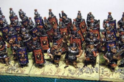 Early Imperial Roman Legionaries
Old Glory legionaries with Donnington, Corvus Belli and Essex officers and LBMS shield transfers. A rare "on the painting table" shot as they have not yet been matt varnished or had static grass added to the bases. 
Keywords: EIR